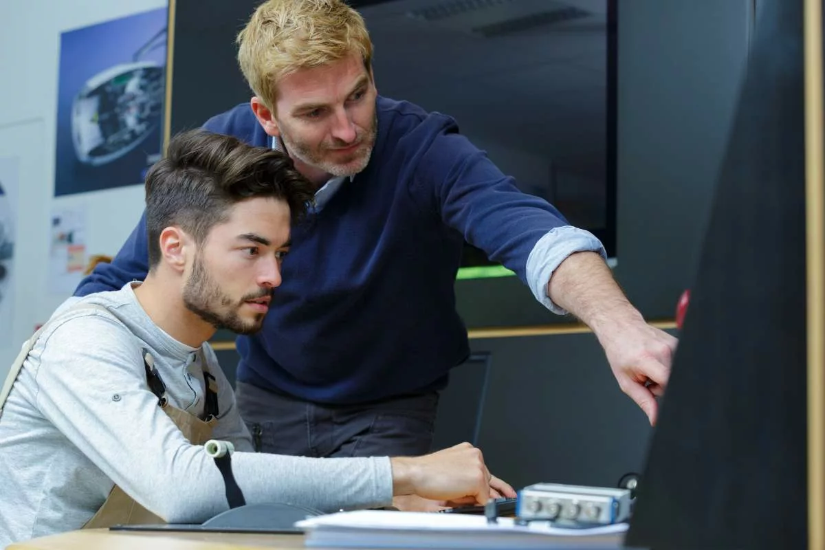 Un tuteur encadrant un jeune en formation dans le cadre de la Prime tuteur Actiris, un dispositif de soutien à l’apprentissage en entreprise.
