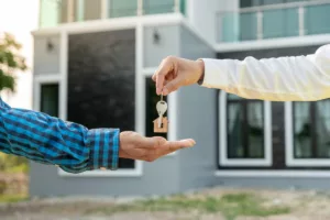 Remise des clés d'une maison à un nouveau locataire, illustrant le processus de signature d'un contrat de bail en Belgique.